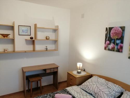 a bedroom with a bed and a table and a desk at APARTMAN NENA in Karlovac