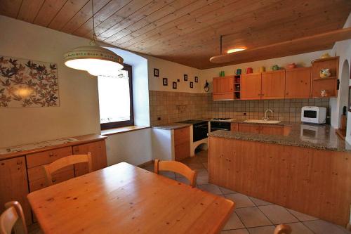 a kitchen with a wooden table and a wooden counter top at Appartamento Casa Delmarco in Castello di Fiemme