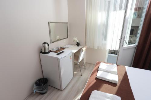 a small white room with a desk and a mirror at BEKSİTİ HOTEL in Yalova