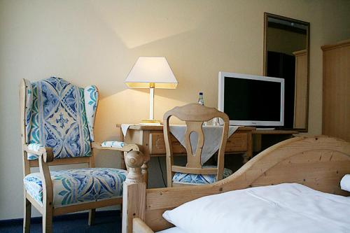 a bedroom with a bed and a desk with a television at Hotel Bad Dürkheim in Bad Dürkheim