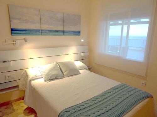 Gran terraza con espectaculares vistas al mar في كابو دي بالوس: غرفة نوم بسرير ابيض ونافذة