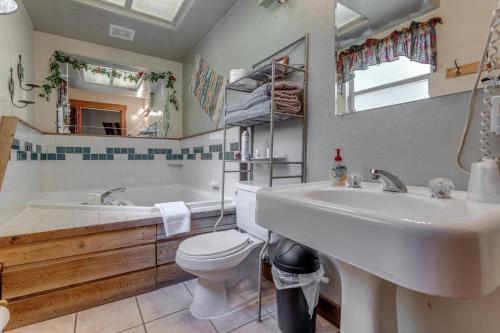 a bathroom with a tub and a sink and a toilet at The Whispering Pines Inn in Norman