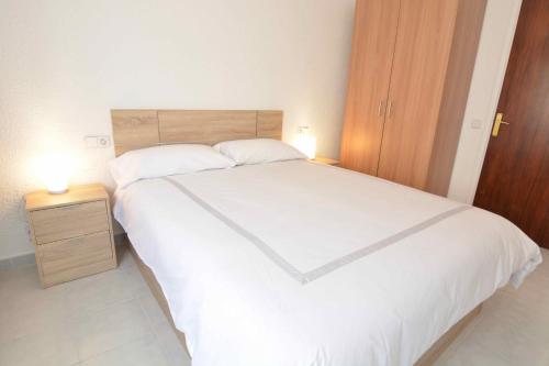 a bedroom with a large white bed and a night stand at Reus Bedrooms 2 habitaciones con baño privado, sin cocina in Reus