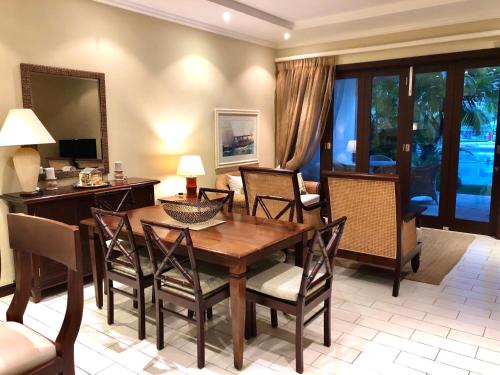 a dining room with a wooden table and chairs at Eden Island Apartment - P14A3 in Eden Island