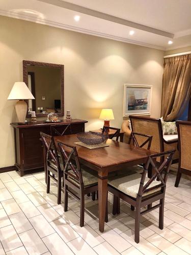 a living room with a wooden table and chairs at Eden Island Apartment - P14A3 in Eden Island