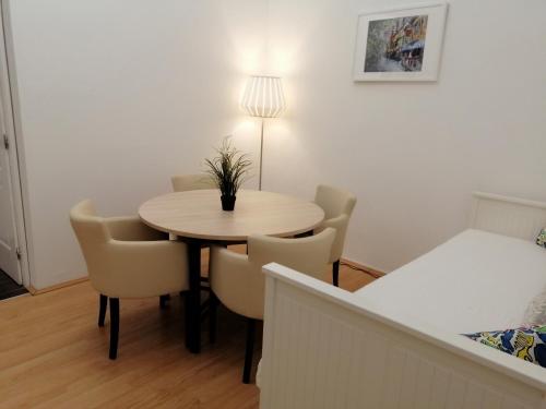 a dining room table with chairs and a lamp at FilinHome Zmaj Jovina Suite in Novi Sad