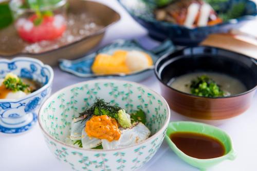 a table topped with bowls of food and soup at Unzen Kyushu Hotel in Unzen