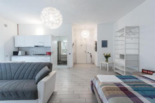 a white living room with a couch and a kitchen at Casa Giovanni in Bergamo