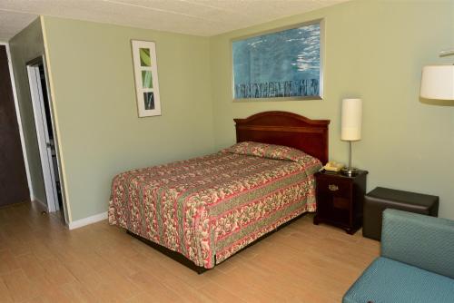 sypialnia z łóżkiem i krzesłem w obiekcie Red Carpet Inn w mieście Houston