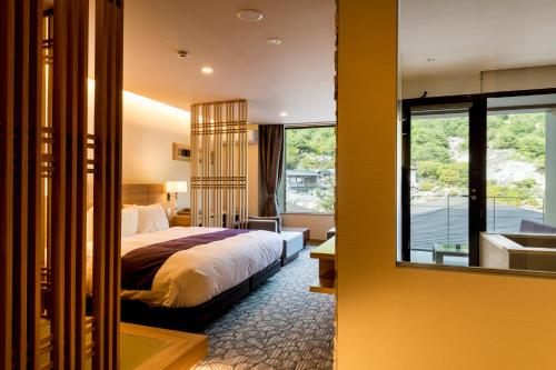 雲仙市にある雲仙九州ホテルのベッドとバスルーム付きのホテルルームです。