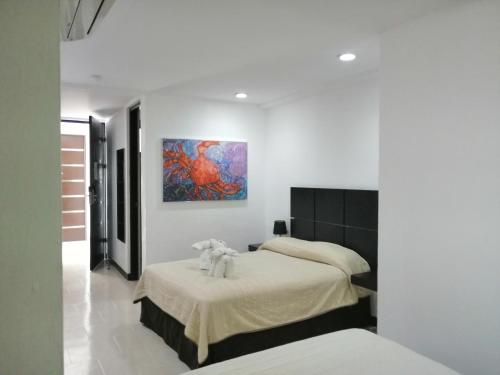 une chambre avec deux lits et un tableau au mur dans l'établissement Hotel Plaza Playa, à Playa del Carmen