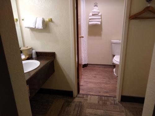 a bathroom with a sink and a toilet and towels at The Wilderness Inn in Enterprise