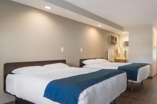 two beds sitting next to each other in a bedroom at Motel 6-Saanichton, BC - Victoria Airport in Saanichton