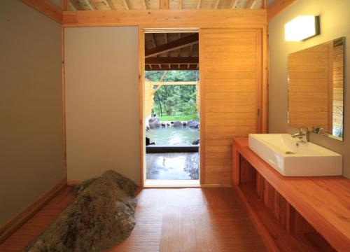 a bathroom with a sink and a window at Lodge Toranoyu in Kokonoe