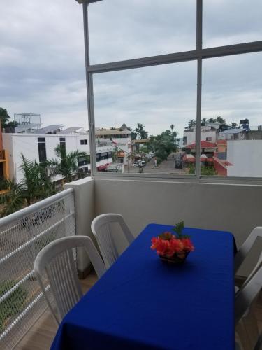 una mesa azul en un balcón con vistas a la calle en Los Bungalitos en Rincon de Guayabitos
