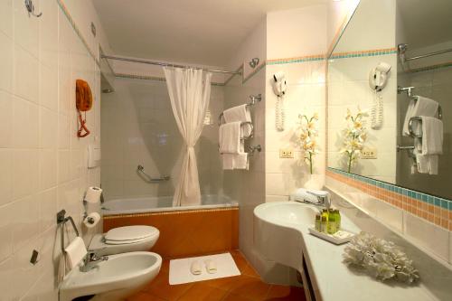 a bathroom with a sink and a toilet and a tub at Hotel De La Pace, Sure Hotel Collection by Best Western in Florence