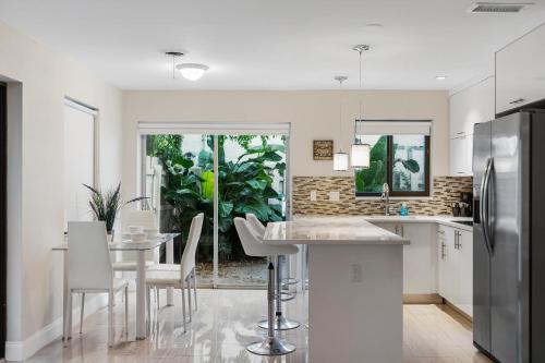 a kitchen with a table and chairs and a refrigerator at Alani Bay Deluxe Condos in Fort Lauderdale
