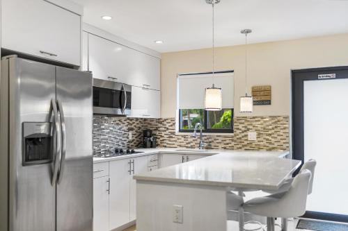 a kitchen with a refrigerator, sink, stove, and microwave at Alani Bay Deluxe Condos in Fort Lauderdale