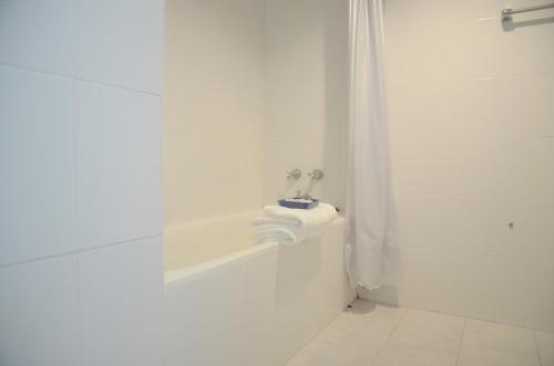 a white bathroom with a tub and a sink at Venice Palace Hotel in Sungai Kolok