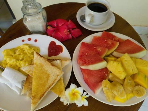a table with two plates of food and a cup of coffee at Aqua Dive Paradise in Tulamben