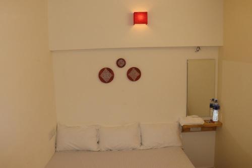 a bedroom with a bed and two plates on the wall at Grand Suites Srirangam in Tiruchchirāppalli
