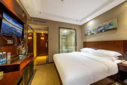 a bedroom with a large white bed and a television at Slowcom┃Yuebei Hotel （Guangzhou Provincial Government) in Guangzhou