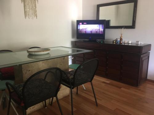 sala de estar con mesa y TV en DEPARTAMENTO ENTERO CORDOBA CERCA DEL KEMPES/CIRCUNVALACION en Córdoba