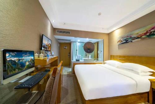 a bedroom with a bed and a desk with a computer at Slowcom┃Yuebei Hotel （Guangzhou Provincial Government) in Guangzhou