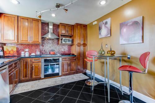 a kitchen with wooden cabinets and red bar stools at House-Canyon Dr in Oceanview