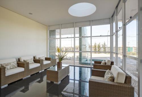 een woonkamer met banken, een tafel en ramen bij Porto Feliz Executive Hotel in Pôrto Feliz