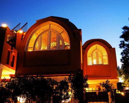 a building with two large windows with lights at Malkata House in Luxor