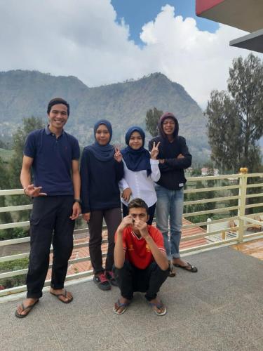 a group of people standing in front of a fence at Bromo Otix Guest House in Bromo