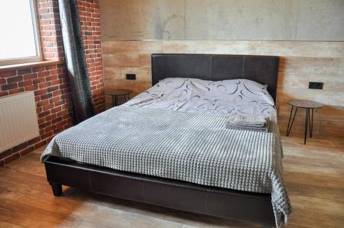 een bed in een kamer met een bakstenen muur bij ЛОФТ НА 26 ЭТАЖЕ in Odessa