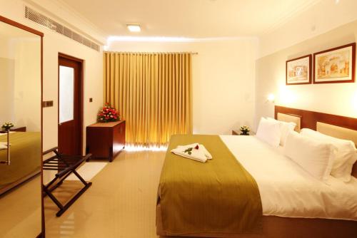 a hotel room with a large bed and a window at SFS Homebridge @ City in Trivandrum