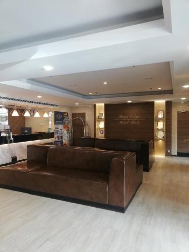 a lobby with a brown leather couch in a room at Regalodge Hotel & Spa Ipoh in Ipoh