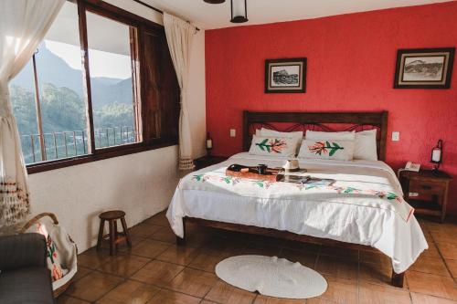 a bedroom with a large bed with a red wall at Hotel San Jorge in Tlatlauquitepec