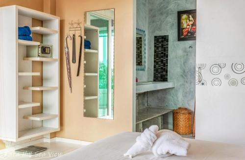 a room with a bed with a mirror and shelves at Hotel Kata Hill Sea View in Kata Beach