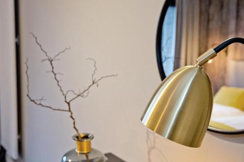 a gold lamp on a table next to a mirror at Gästehaus des Elsa Brändström Haus in Hamburg