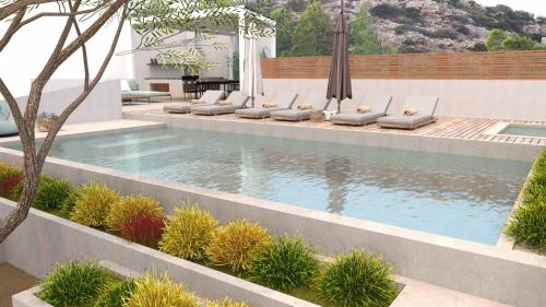 a swimming pool with lounge chairs next to a building at Beachfront Villa on Crete - Kirvas, member of Pelagaios Villas in Koutsounari