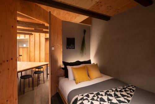 Contexted Boutique Villa في أوساكا: غرفة نوم صغيرة مع سرير وطاولة