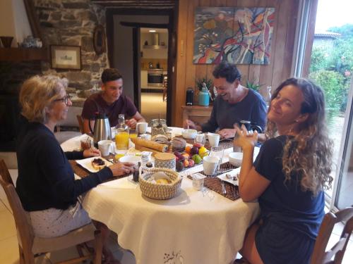 Chein-DessusにあるLe Balcon Commingeoisのテーブルの周りに座って食事をとる人々のグループ