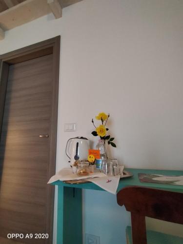 a table with a coffee maker and flowers on it at B&B Madonna degli Airali in Vezza d'Alba