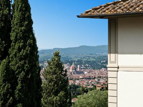 a view of a city from a building with trees at FH55 Hotel Villa Fiesole in Fiesole