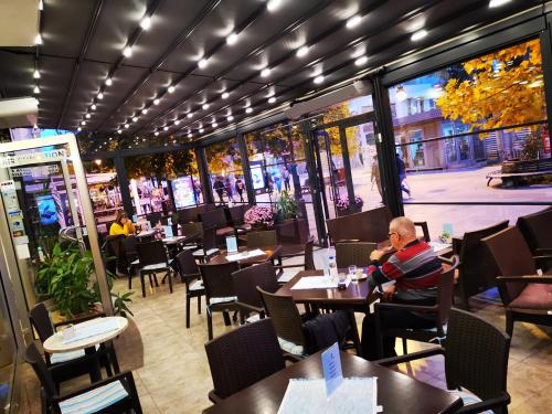 un homme assis à une table dans un restaurant dans l'établissement Best Western Hotel Turist - Superior, à Skopje