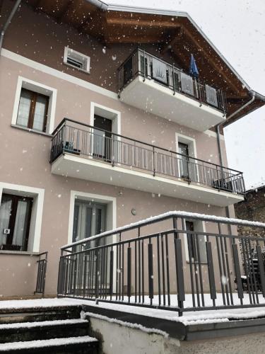 un edificio con nieve cayendo en su balcón en La Casa di Olivo, en Tassullo