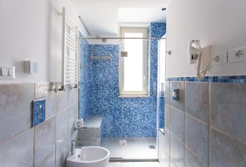 a bathroom with a toilet and a shower with blue tiles at Residenza Wagner in Palermo