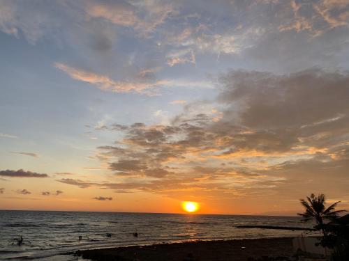 a sunset on the beach with the sun setting at Kobe's Beachfront Haven in Siquijor