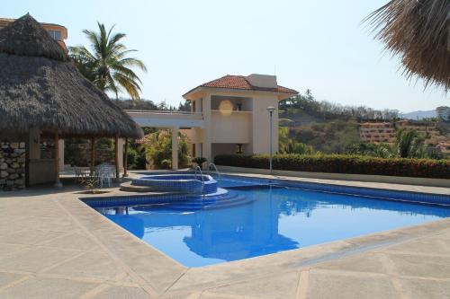 a swimming pool in front of a villa at Villas del Palmar Manzanillo with Beach Club in Manzanillo