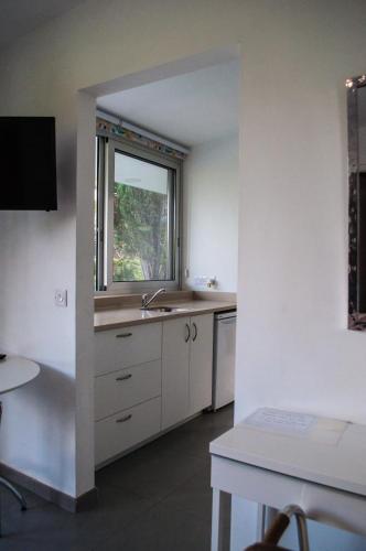 a kitchen with a sink and a window at Idyllic studio with private pool in Nicosia