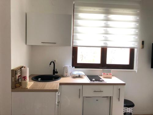 a white kitchen with a sink and a window at Dream Apartments in Mostar